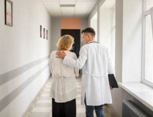 Médico acompanhando paciente no corredor